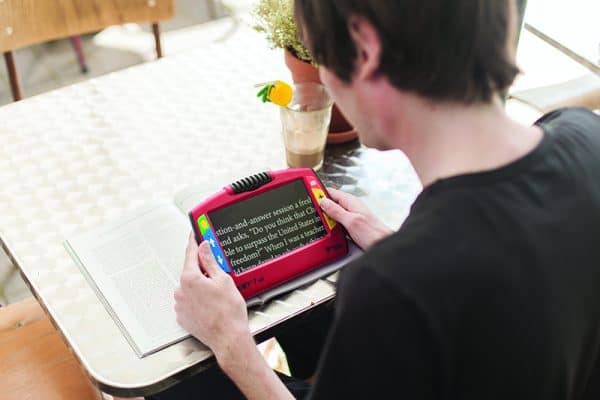 Image of boy using Ruby 7 to read book - magnifying text