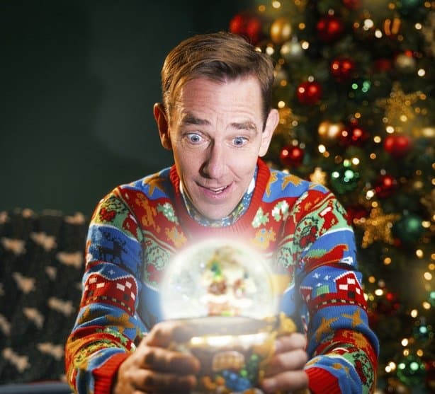 Image of Ryan Tubridy in a Christmas jumper, looking into a snowglobe